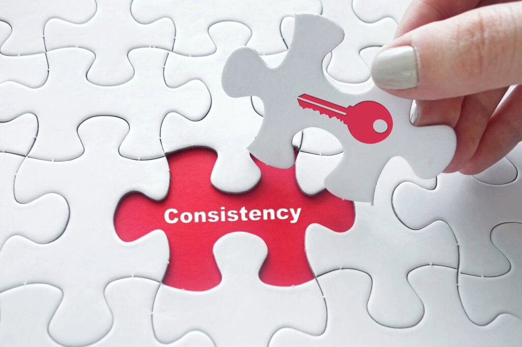 A puzzle with a missing peace that reads consistency