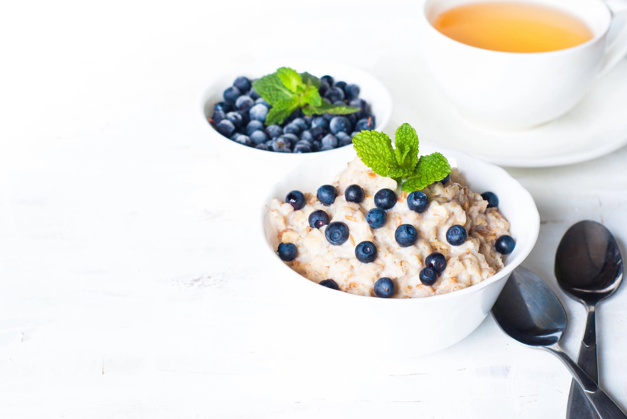 Bowl of oatmeal topped with blueberries and fresh mint for a high fiber meal