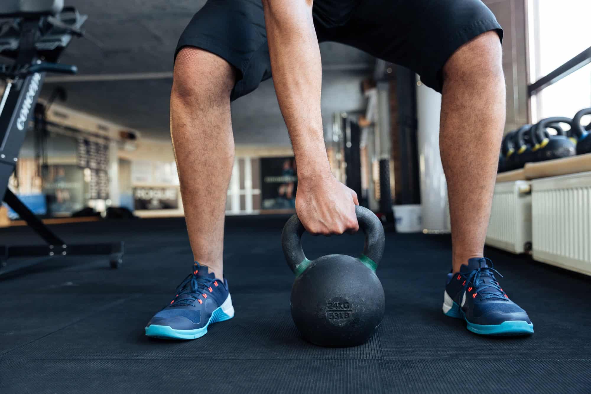 Man using a kettleball in a high-intensity full body workout