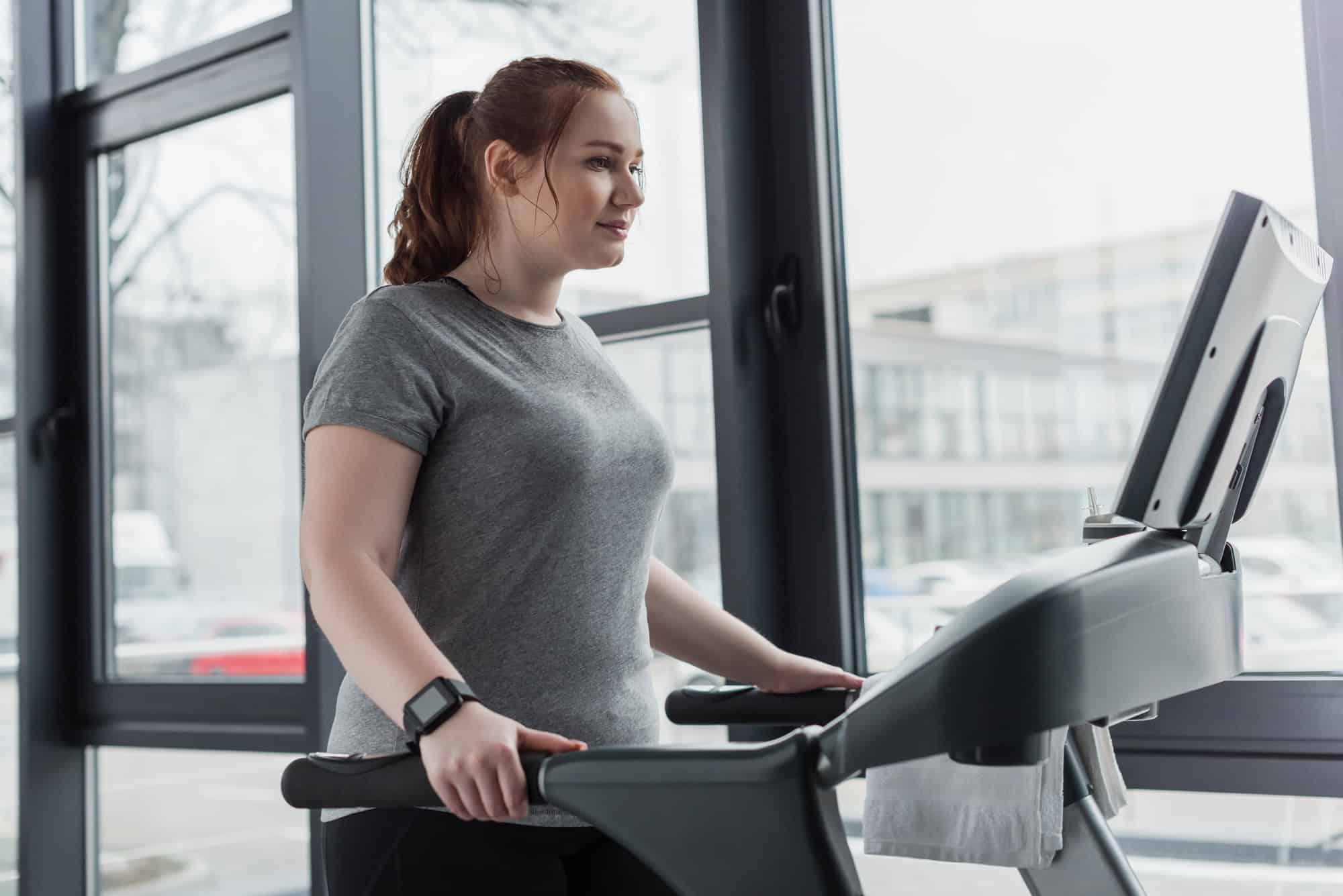 Woman walking on a treadmill as part of a female beginner workout plan for low-impact cardio