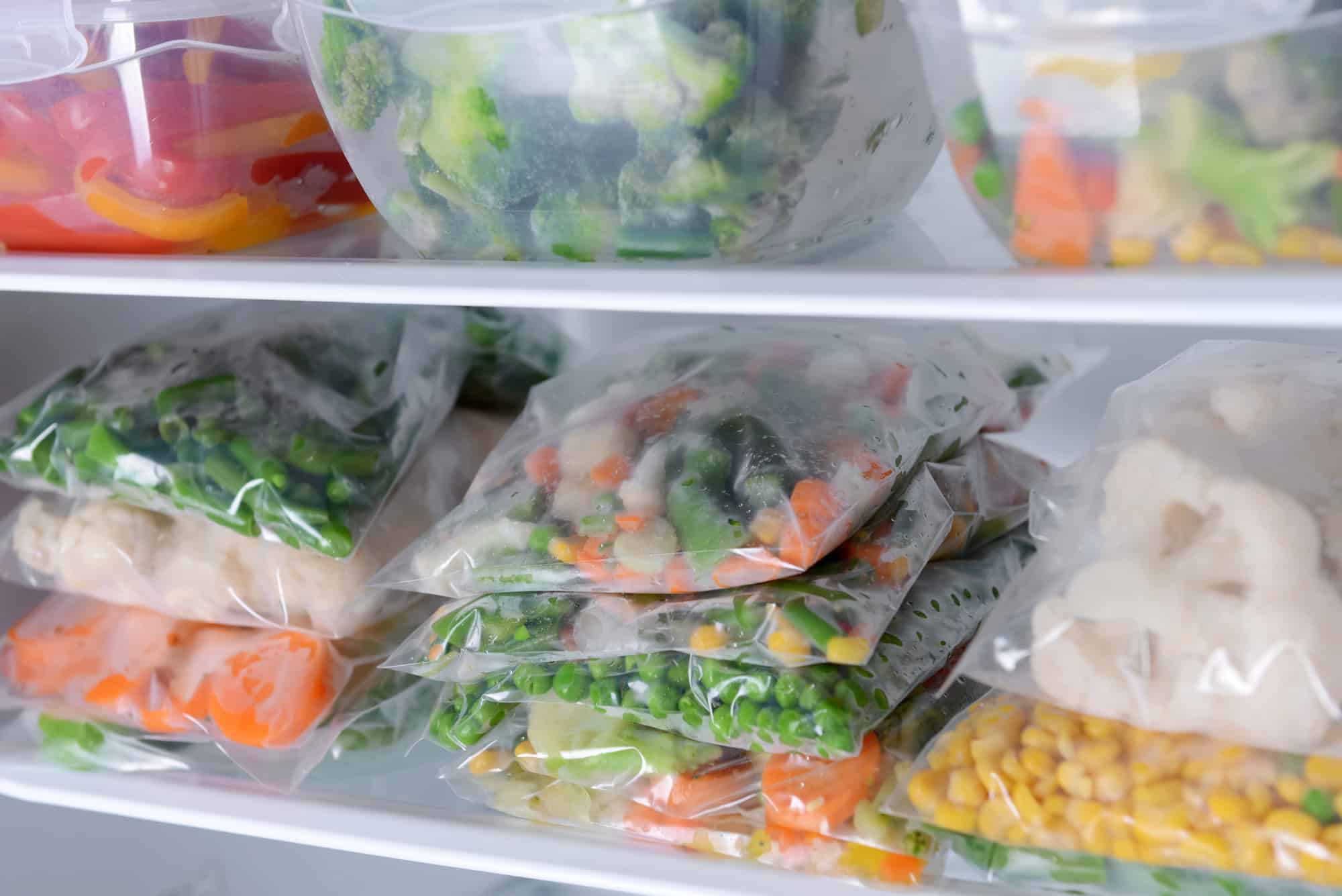 High Protein Frozen Meals – Bulk Frozen Veggies for Easy Add-Ins Assorted frozen vegetables and meat in zip bags stored in a freezer as part of high protein frozen meals