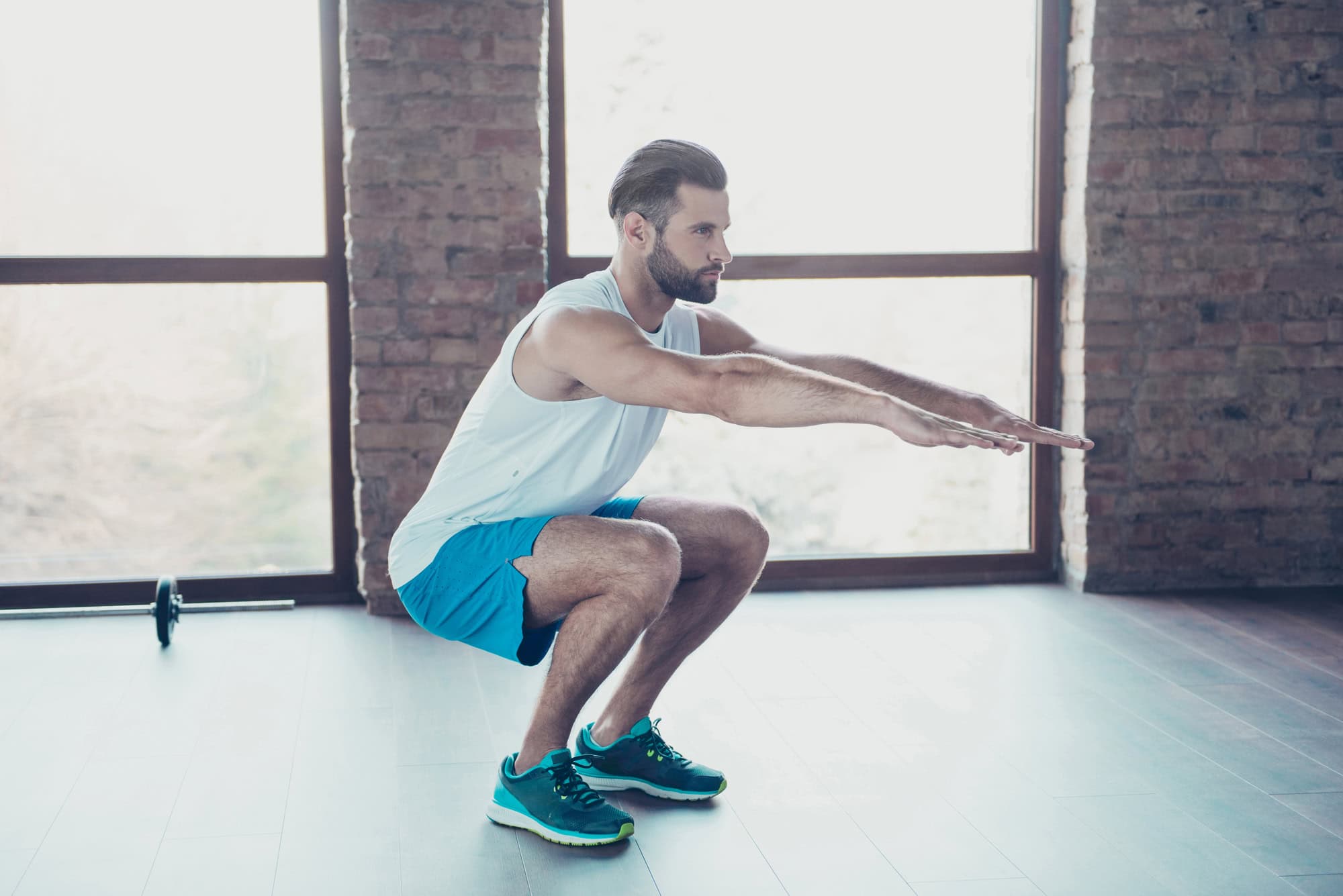 Man doing bodyweight squats as part of a bodyweight leg workout for strength and tone