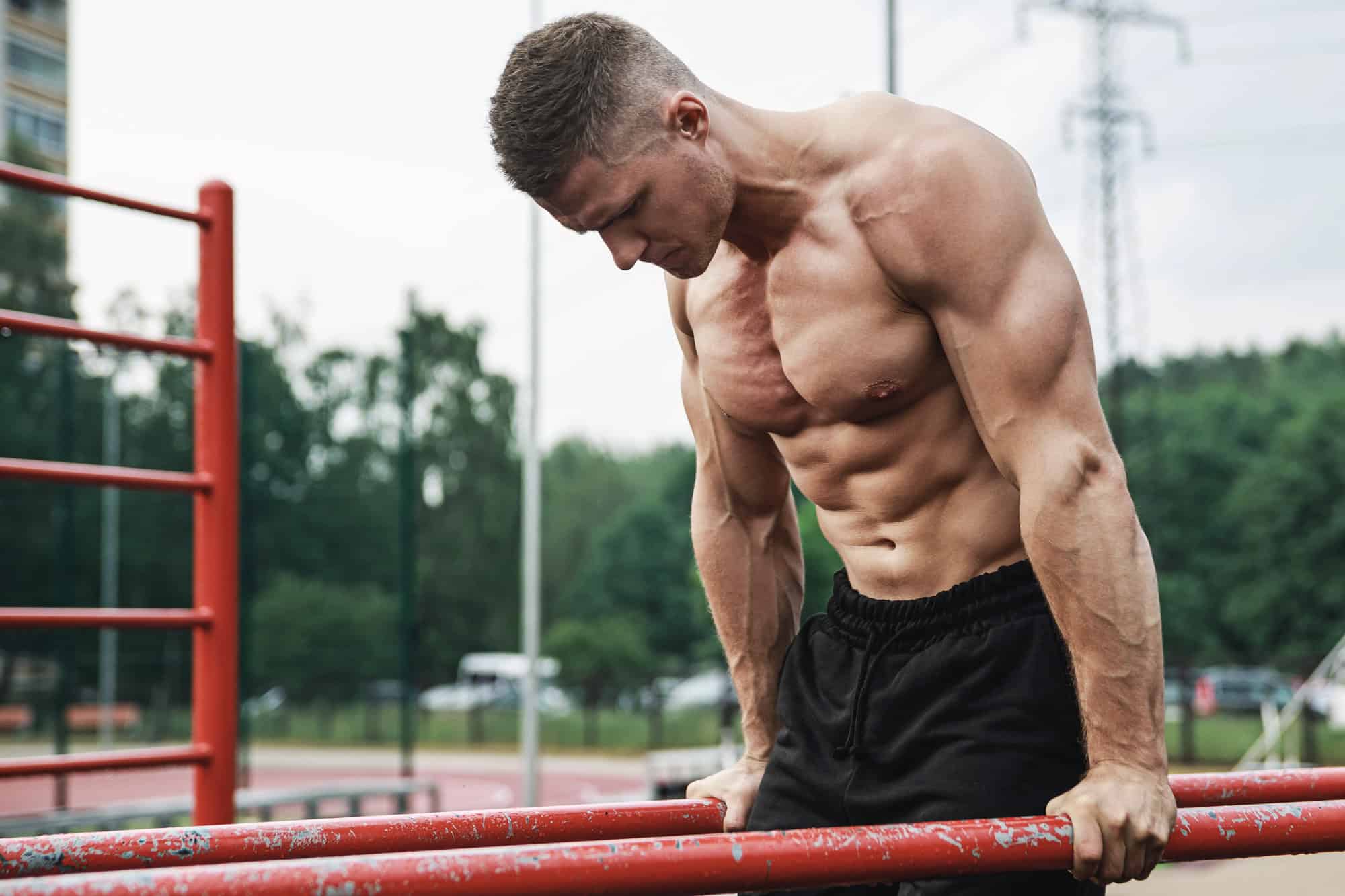 Man doing bodyweight dips on parallel bars to build triceps and upper body strength