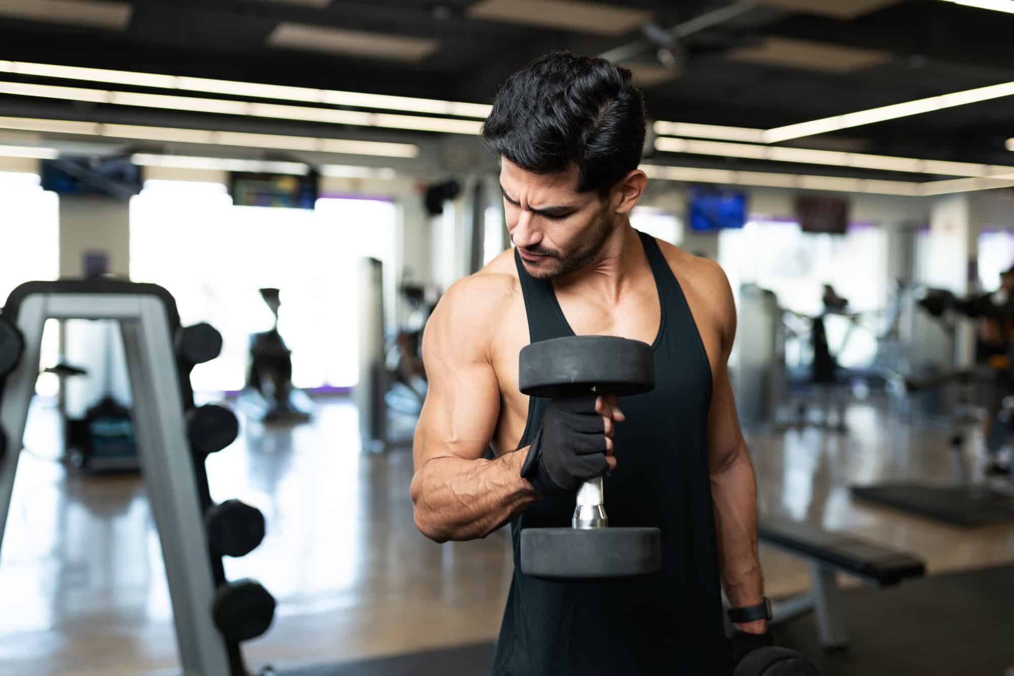 Man performing dumbbell curls during a biceps workout to build arm strength and size