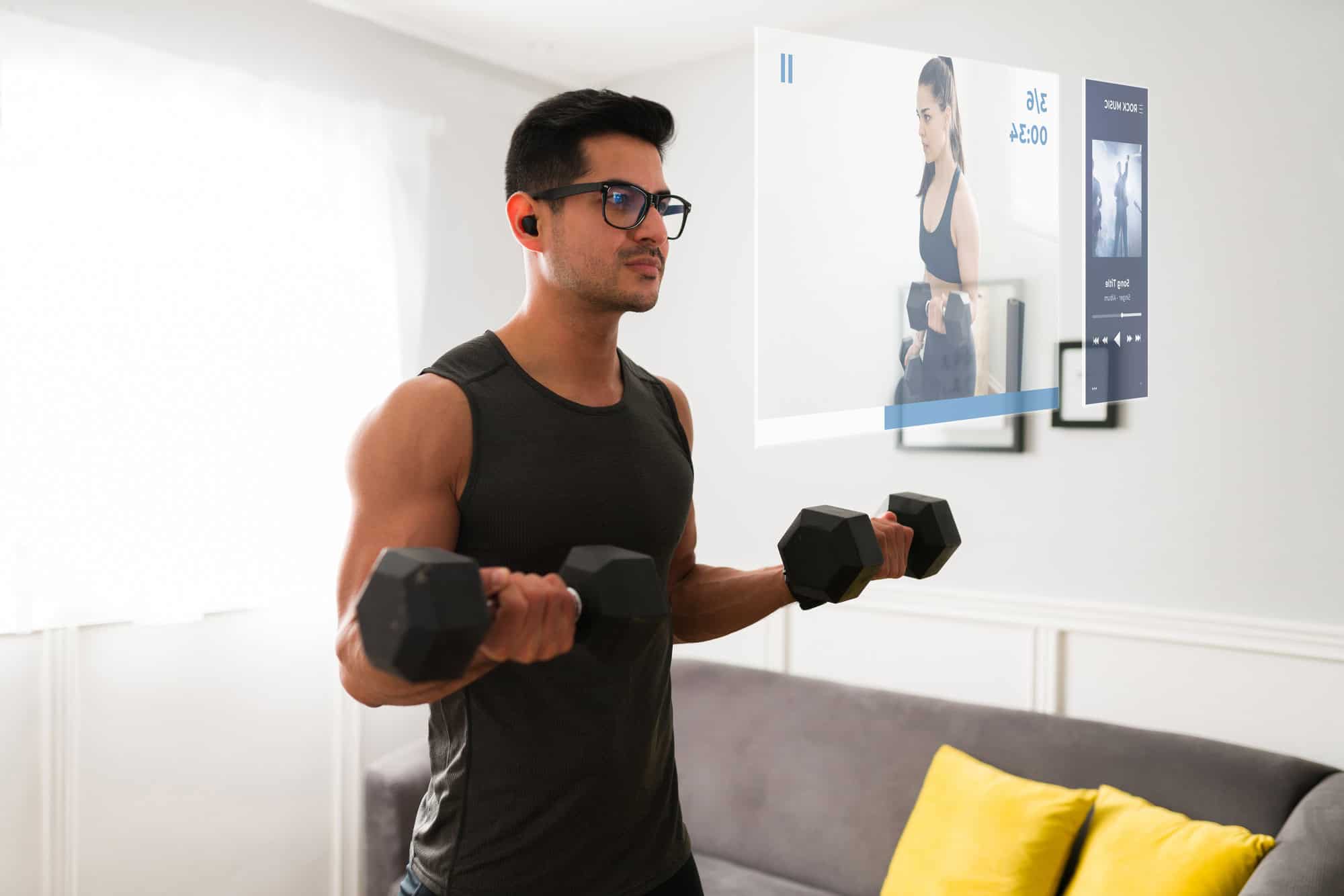 Gym Arm Workout – Dumbbell Curls at Home with Virtual Coaching Man doing biceps curls at home while watching a virtual workout on a smart display