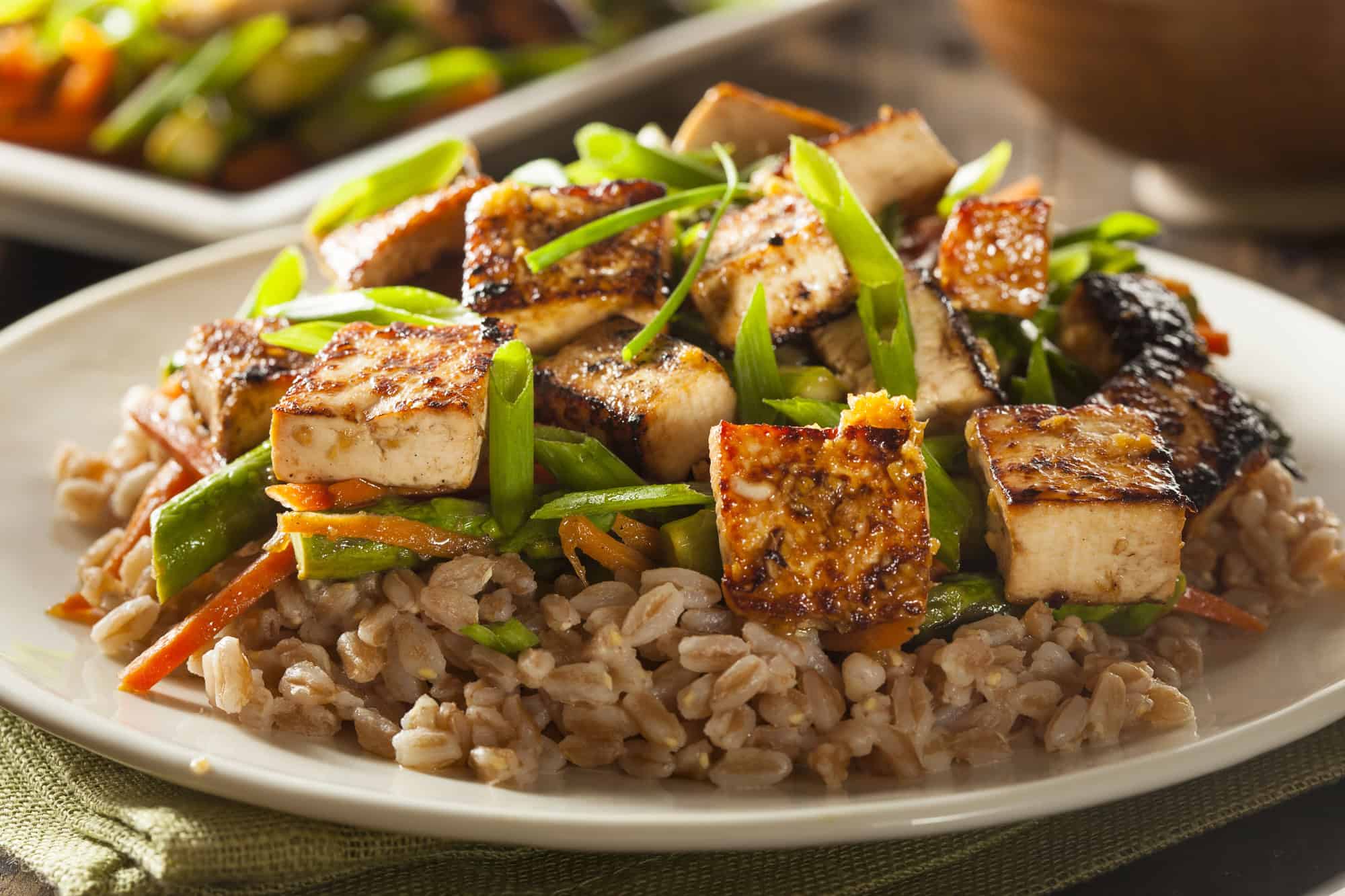 High Protein Vegetarian Meals – Tofu and Veggie Stir-Fry Grilled tofu cubes served with vegetables and grains for a high protein vegetarian meal
