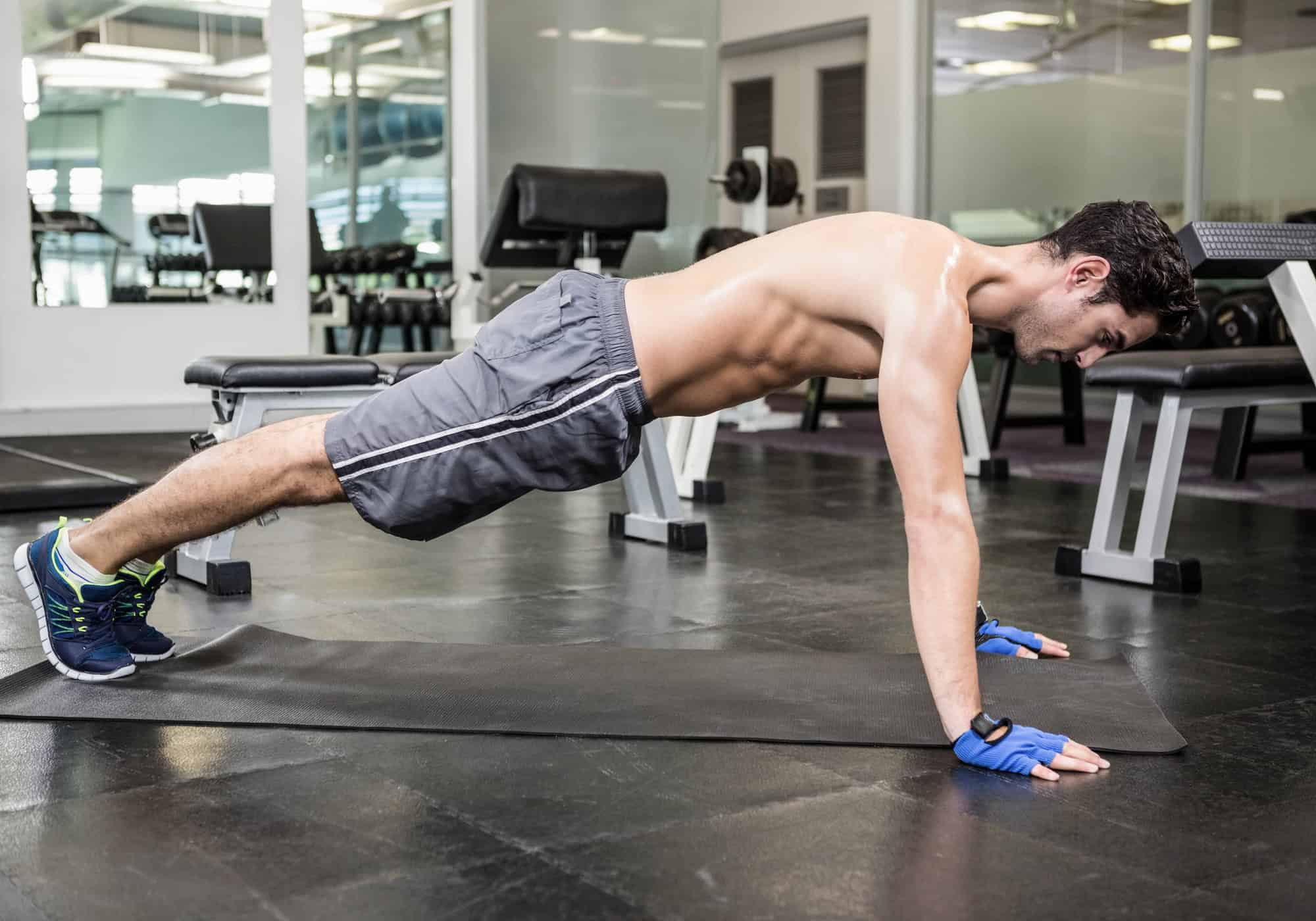 Man in push-up position during a bodyweight arm workout for upper body strength