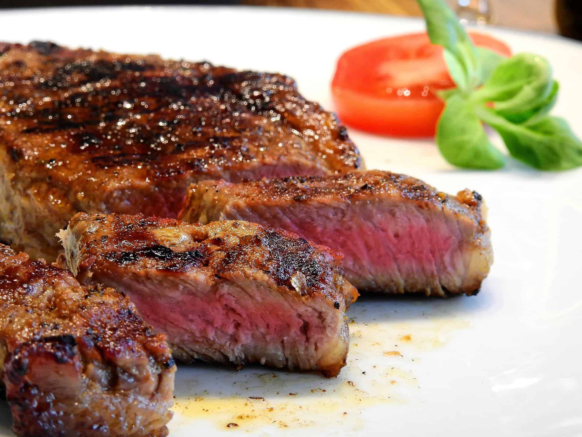 Sliced grilled steak served with tomato and greens as a high protein low calorie lunch option